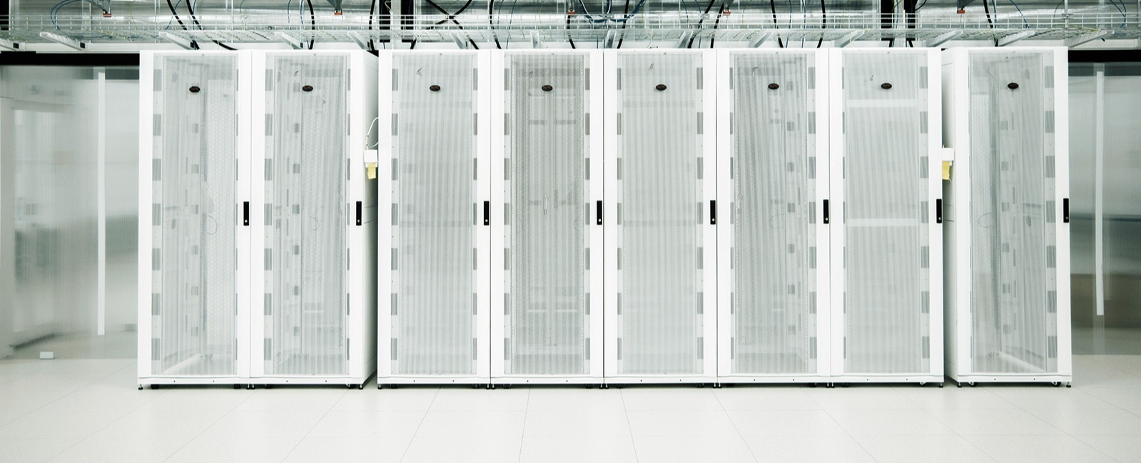 Rows of white server cabinets inside a data center Rows of white server cabinets inside a data center